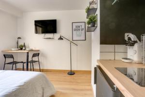 kuchnia z łóżkiem i stołem z krzesłami w obiekcie Suites indépendantes toutes équipées Leopold ou Carnot w Nancy