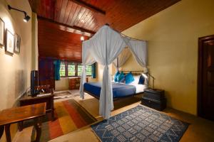 a bedroom with a bed with a canopy at Ferncliff Bungalow in Nuwara Eliya