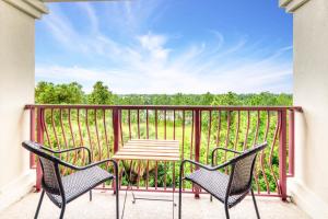 un patio con 2 sillas y una mesa en el balcón en Pool*Top Floor*Forest Views*Balcony*VistaCay en Orlando