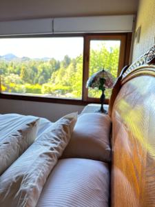a bedroom with a couch and a large window at Le Bouquet Apart Hotel in San Carlos de Bariloche
