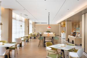 um restaurante com mesas e cadeiras e uma cafetaria em Home2 Suite by Hilton Wenzhou Wencheng em Wenzhou