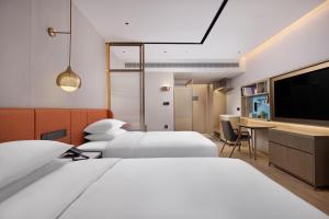 a hotel room with two beds and a flat screen tv at Home2 Suite by Hilton Wenzhou Wencheng in Wenzhou
