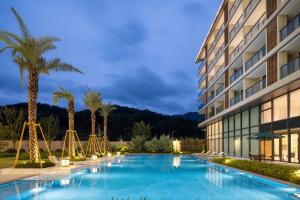 a swimming pool in front of a building at Home2 Suite by Hilton Wenzhou Wencheng in Wenzhou