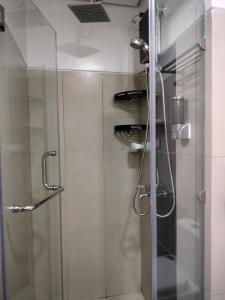 een douche in een badkamer met een glazen deur bij Smdc Breeze Residence in Manilla