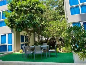 a table and chairs in front of a building at Large 2 BR Condo, Grand Avenue, Central Pattaya in Pattaya