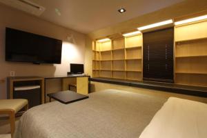 a bedroom with a bed and a flat screen tv at Boutique Hotel K-Oido in Siheung
