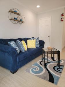 Sofá azul en la sala de estar con mesa en Sheer Bliss BeachView Apt #4 en Exuma Harbour Estates