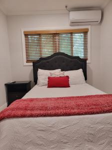 - une chambre avec un grand lit et un oreiller rouge dans l'établissement Sheer Bliss BeachView Apt #4, à Exuma Harbour Estates