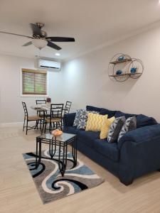 uma sala de estar com um sofá azul e uma mesa em Sheer Bliss BeachView Apt #4 em Exuma Harbour Estates