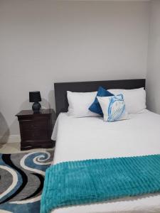 a bedroom with a bed with a green blanket on it at Sheer Bliss BeachView Apt #4 in Exuma Harbour Estates