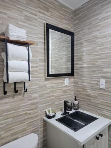 y baño con lavabo, espejo y aseo. en Sheer Bliss BeachView Apt #4, en Exuma Harbour Estates