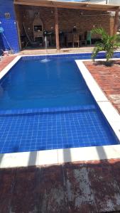 a swimming pool with blue tiles on the ground at Casa de ponta de pedras in Goiana