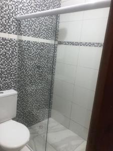 a bathroom with a glass shower with a toilet at Casa de ponta de pedras in Goiana