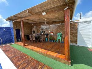 an outdoor deck with a table and chairs at Casa de ponta de pedras in Goiana