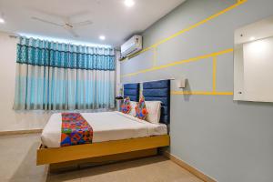 a bedroom with a bed and a window at FabHotel JKC Grand in Hyderabad