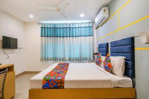 a bedroom with a bed and a television at FabHotel JKC Grand in Hyderabad