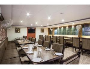 a dining room with wooden tables and chairs at Hotel Wardhman, Jabalpur in Jabalpur