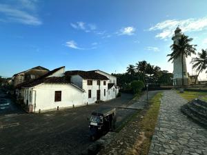 a truck parked next to a building and a clock tower at 89 Leyn Baan by AQUA Villa in Galle