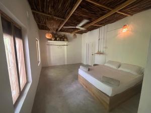 um quarto com uma cama grande num quarto em KOMOREBI MADIHA em Madihe East