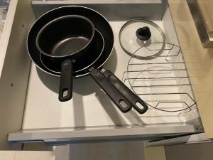 a pan and a strainer on top of a stove at Large Ground Floor Condo, Grand Avenue, Central Pattaya in Pattaya Central