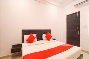 a bedroom with a large bed with red pillows at OYO Flagship Metro Inn in Chinhat