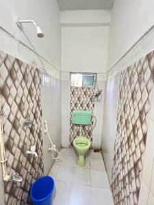 a bathroom with a green toilet and a shower at Anuja Lodge 