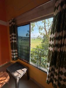 a room with a window with a bench and a view at Anuja Lodge 