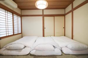 1 cama blanca grande en una habitación con ventanas en Relax House Misato, en Shiraoi