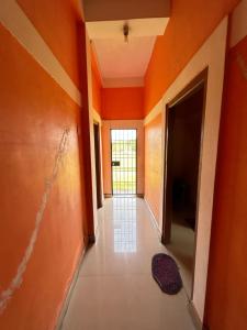 an empty hallway with orange walls and a door at Anuja Lodge 