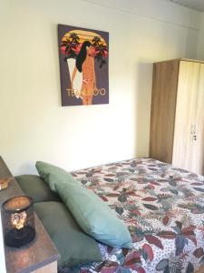 - une chambre avec un lit et une photo sur le mur dans l'établissement Fare Kairos, à Uturoa