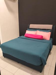 a bed with two colorful pillows on top of it at Asmar's Homestay Alor Setar in Alor Setar