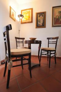 Habitación con 3 sillas, mesa y lámpara. en Villa La Certosa, en Pisa