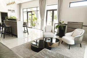 sala de estar con 2 sillas y mesa en SHALOM HOUSE _ BẢO LỘC en Bao Loc