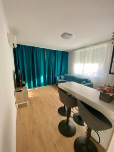 a living room with a table and a blue couch at PannaRoza Apartman in Balatonlelle
