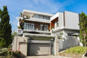 una casa blanca con un garaje delante en SHALOM HOUSE _ BẢO LỘC, en Bao Loc