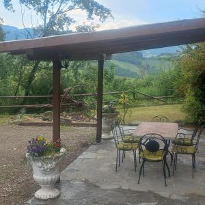 un patio con mesa y sillas bajo una pérgola en Raggio Campacci di Sacchetti Vanessa, 