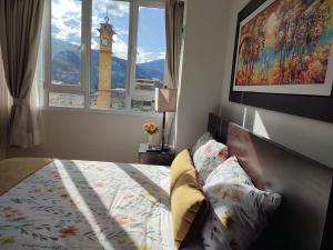 a bedroom with a bed with a clock tower in the window at Chanka Suites in Talavera