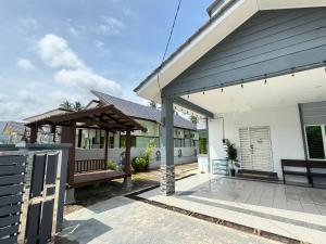 una casa con un portico con una panchina di fronte di OH MY BATU RAKIT HOMESTAY Terengganu a Kuala Terengganu