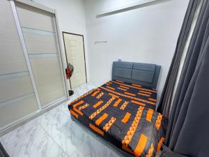una camera da letto con un letto e un piumone arancione di OH MY BATU RAKIT HOMESTAY Terengganu a Kuala Terengganu