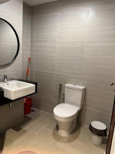 a bathroom with a white toilet and a sink at West Vista Studio Apartment with Netflix in Jakarta