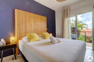 a bedroom with a large bed with a large window at Ti Kaz Bellevue - villa avec vue mer - jacuzzi - Saint-Denis in Saint-Denis