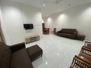 ein Wohnzimmer mit Sofas und einem Flachbild-TV in der Unterkunft Homestay Selayang D Kepong in Kuala Lumpur