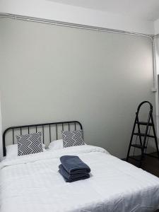 a bed with two towels on top of it at Tolomhouse in Hat Yai