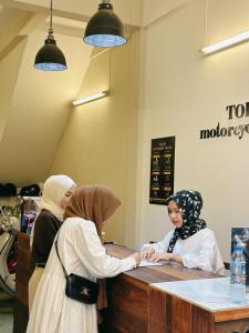 two women are standing at a counter in a store at Tolomhouse in Hat Yai