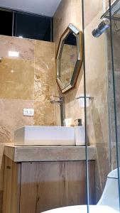 uma casa de banho com um lavatório e um espelho em Chanka Suites em Talavera