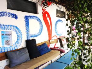 a couch sitting in front of a wall with a sign at Spicy23 - M' Pai Bay in Sihanoukville