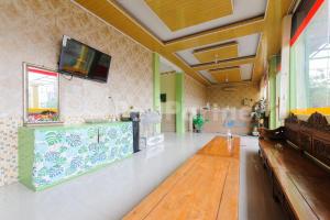 a living room with a tv on the wall at Homestay Hj Suharti Natar Lampung RedPartner in Negarasaka