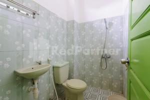 a bathroom with a toilet and a sink at Homestay Hj Suharti Natar Lampung RedPartner in Negarasaka