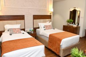 Una cama o camas en una habitación de Nalapad's Hotel Bangalore International