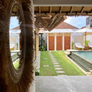 an external view of a house with a swimming pool at NOMAD Tropical Hostel Canggu in Dalung